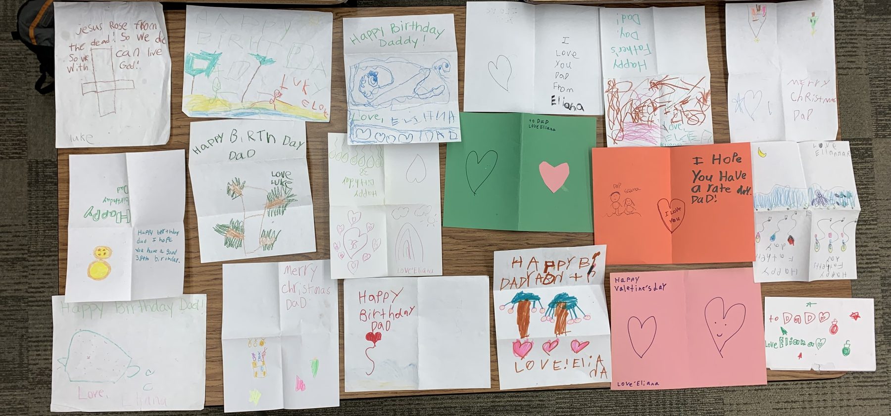 A table covered with handmade cards from my children, collected over more than a decade — birthdays, Father&rsquo;s Day, Christmas, and just-because notes.